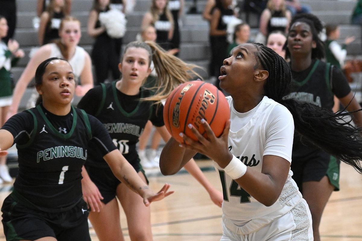 Ridgeline forward Habiba Adam shoots against Peninsula guard Daisy Peay (1) during a State 3A play-in game in Liberty Lake on Tuesday.  (James Snook/THE SPOKESMAN-REVIEW)