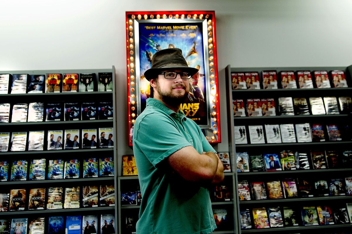 Store employee Kolton Koppa stands before shelves of movies at Video Theater in Coeur d’Alene. Video Theater, which also operates a store in Post Falls, is the only independently owned video rental shop still in operation in the area. (Kathy Plonka)