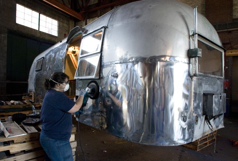 WSU design student Shona Bose buffs the shine back onto the shell of a 1958 Airstream.  Design students are involved in an eight-week course to redesign the classic travel trailer, aiming to create a new interior for a modern user.  (Colin Mulvany)