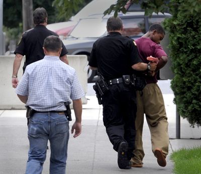 Demetruis Glenn, far right, is forcibly redirected by authorities Aug. 26 after turning to try to view onlookers who were hollering words of support for him near the county’s juvenile jail. Glenn was the first suspect arrested in connection to the death of Delbert Belton. (Jesse Tinsley)