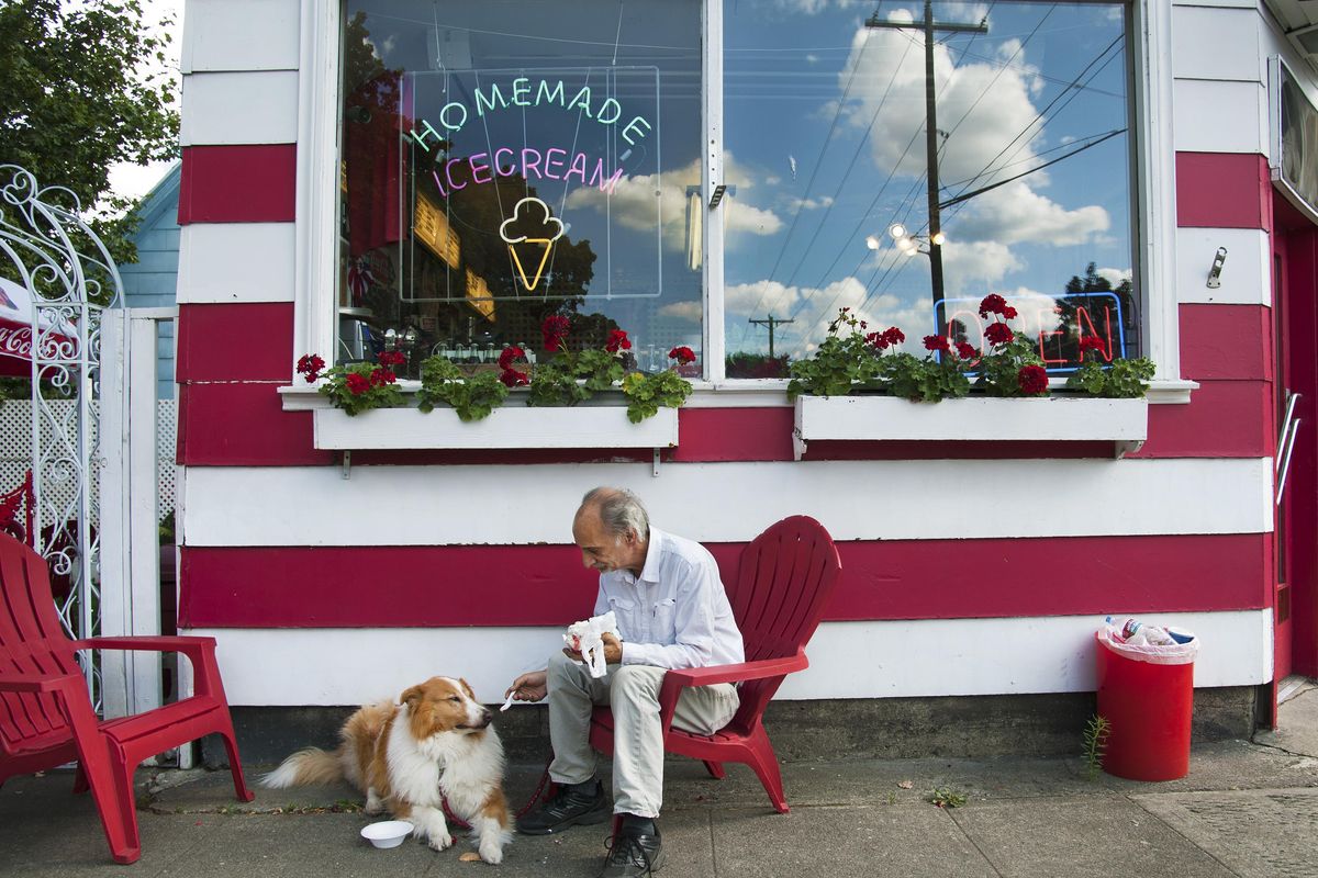 Randy Muscarella offers a taste of his banana split to his 10-year-old rough collie, Whiskey, July 14, 2015, outside Doyle