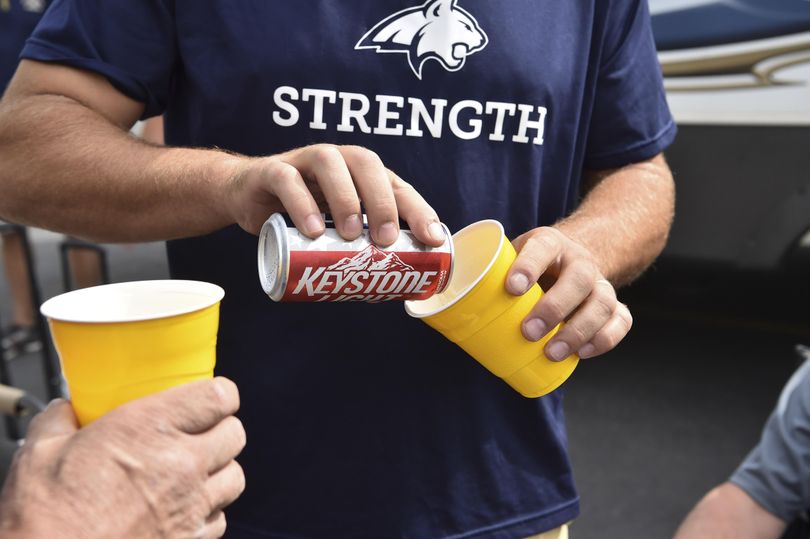 Montana State fan Mark D-Agostino, right, pours a beer for friend Jerry Johnson before the start of a college football game against Idaho on Thursday, Sep 1, 2016, outside the Kibbie Dome in Moscow, Idaho. The Montanans said they were unfazed by Idaho’s new tailgating laws prohibiting alcohol and planned to serve beverages in plastic cups. (Tyler Tjomsland / The Spokesman-Review)