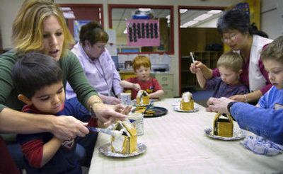 
Speech language pathologist Erika Johnson, left, assists preschooler Ryan Palting during a gingerbread-making class at University Center on Wednesday. Central Valley has consolidated several special-education programs into the Reinforcing Early Educational Achievements in Children (REEACH) program. 
 (Holly Pickett / The Spokesman-Review)