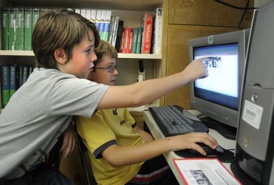 Jefferson Elementary school fifth-graders in the Montessori Program, Isaac Petrie, left, and Quinn Kopczynski, make adjustments to their presentation on the Beatles break-up for the school’s timeline displayed in the hallway. Jefferson is celebrating the school’s 100 anniversary. (Dan Pelle / The Spokesman-Review)