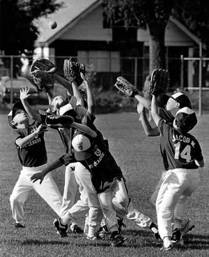 Before their big game at Holmes Elementary in Spokane, “I got it!” is yelled in unison as these little leaguers try and catch fly balls hit by their coach in spring of 1993. (COLIN MULVANY/The Spokesman-Review)