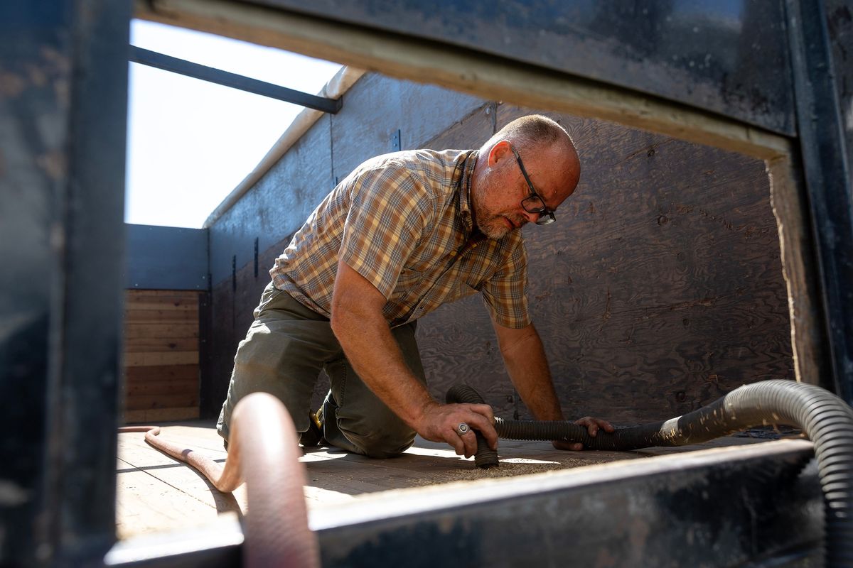 Don McMoran vacuums tall fescue seeds from a seed truck box in preparation to haul ryegrass seed on Aug. 20 in Mount Vernon, Wash.  (Nick Wagner/The Seattle Times/TNS)
