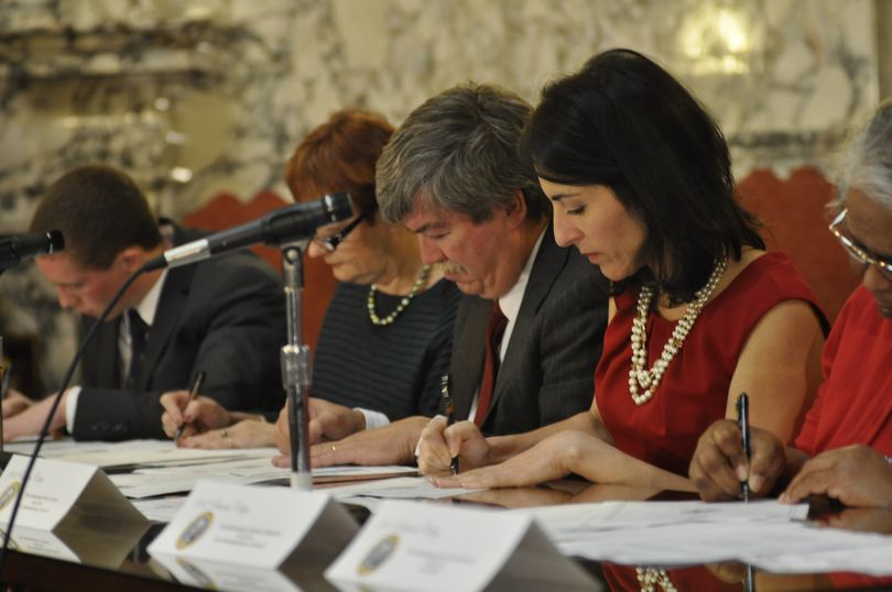 OLYMPIA -- Members of the Electoral College, including Rick Lloyd of Spokane Valley, center,  sign paperwork casting Washington's electoral votes for Barack Obama for president. Also in the picture, from left, are Grifynn Clay, Kathleen Lawrence and Maria Ehsam and Georgia Spencer.  (Jim Camden)