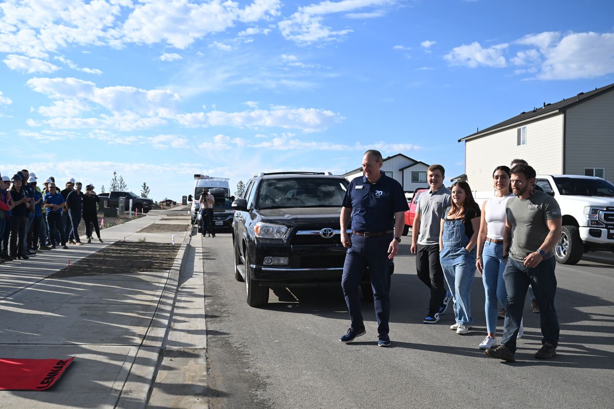 From right, U.S. Air Force veteran Christopher Weichman walks to his new home site with fiancee Carlotta Margheri, his daughter Ruby, 17, and son, Tyson, 14, and Bill Salvesen, northwest division president of Lennar Homes, which took the lead in awarding Weichman a free home in a neighborhood under construction in north Spokane.  (Jesse Tinsley/THE SPOKESMAN-REVIEW)