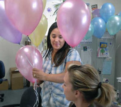
Susan Chandler, CHAS immunization coordinator gives Malia Ethredge a balloon at the clinic.
 (The Spokesman-Review)