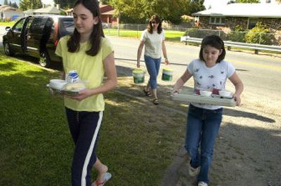 Eleven-year-old Kate Lathan, left, her sister Christy, 9, and mom, Cindy, deliver hot meals Tuesday in Spokane Valley. The Lathans have been volunteering with Spokane Valley Meals on Wheels for more than nine years.
(Photos by Colin Mulvany / The Spokesman-Review)