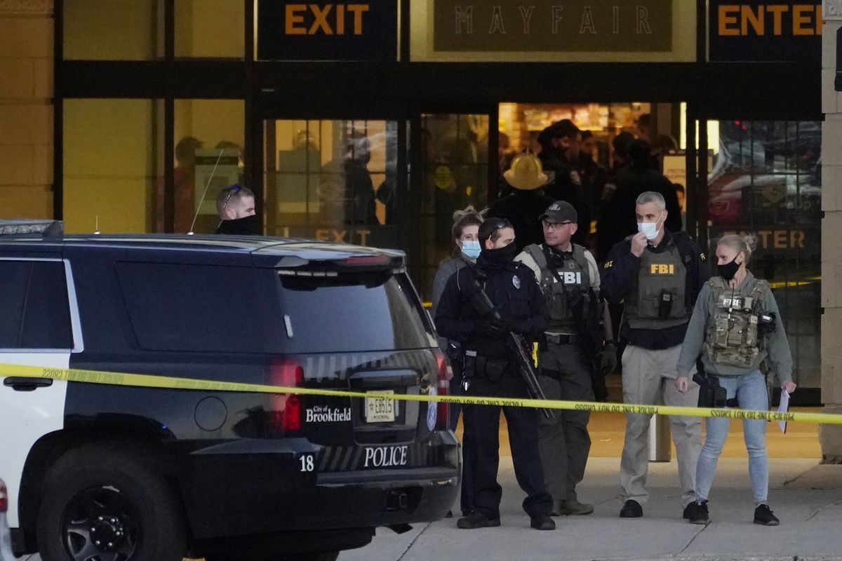 FBI officials and police stand outside the Mayfair Mall after a shooting, Friday, Nov. 20, 2020, in Wauwatosa, Wis. Multiple people were shot Friday afternoon at the mall. Wauwatosa Mayor Dennis McBride says in a statement that a suspect remains at large after the shooting at Mayfair Mall. (Nam Y. Huh)