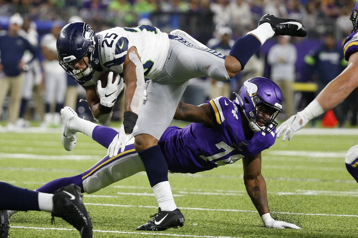 Seattle Seahawks running back Travis Homer (25) is tackled by Minnesota Vikings defensive end Stacy Keely, rear, during the second half of an NFL preseason football game, Sunday, Aug. 18, 2019, in Minneapolis. The Vikings won 25-19. (Bruce Kluckhohn / Associated Press)
