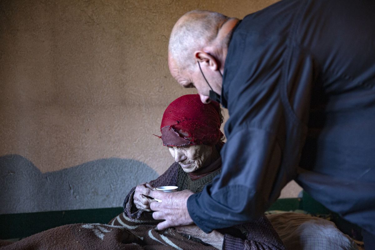 Kosovo Albanian Fadil Rama, right, holds a cup of water for a Kosovo Serb Blagica Dicic.  (Visar Kryeziu)