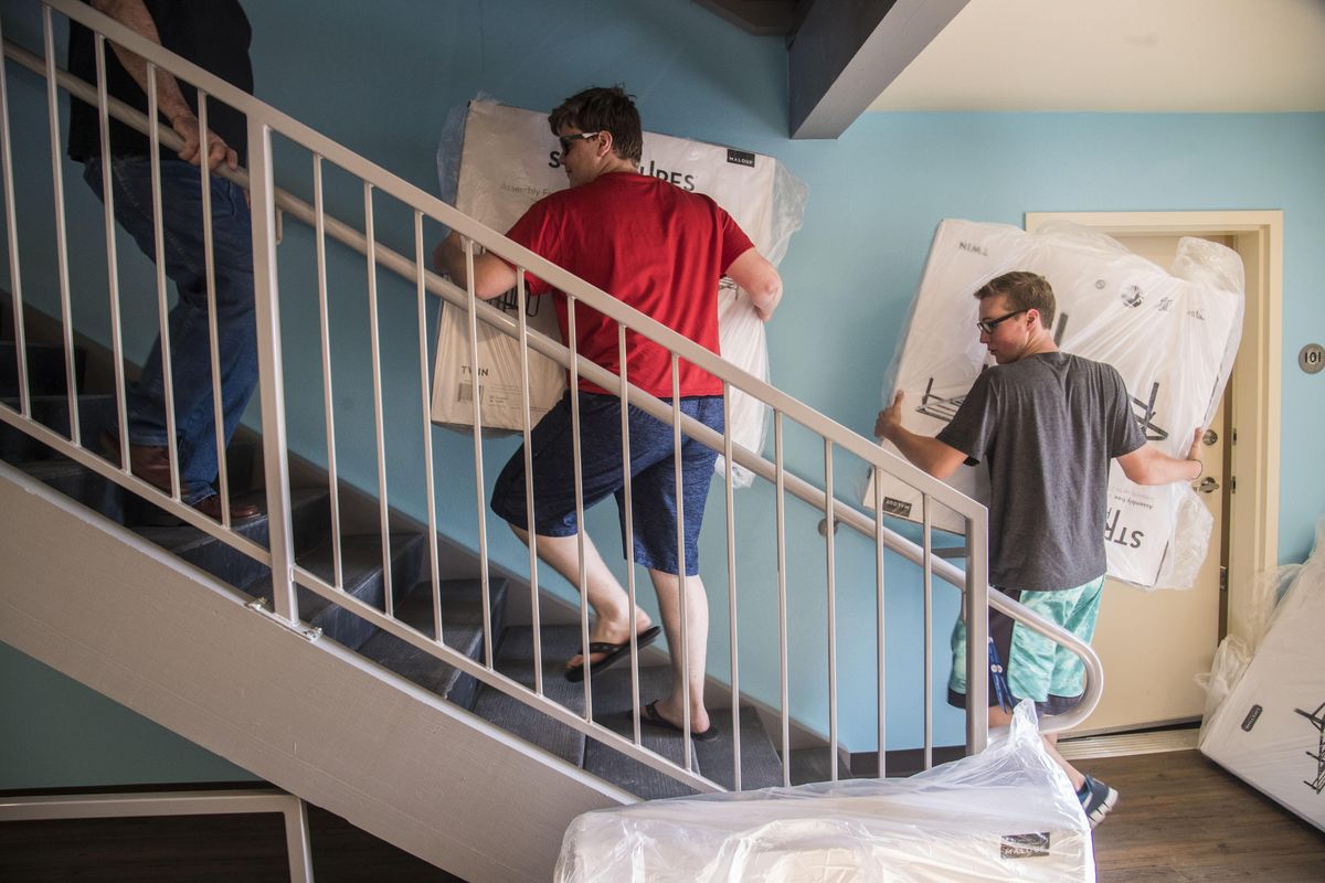 Volunteers Jacob Martinez and Sean Fuller load bed frames up stairs to units in the Pope Francis Haven House, July 20, 2017, in Spokane Valley, Wash. The Mormon Church donated 200 bed to the Catholic Charities homeless housing project. (Dan Pelle / The Spokesman-Review)