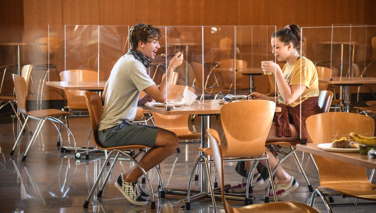 Whitworth University sophomore Trenton Leslie, left, and junior Meredith Fultz eat lunch behind plexiglass barriers designed to curb the spread of the coronavirus in the Hixson Union Building on Thursday, Aug. 27, 2020.  (Dan Pelle / The Spokesman-Review)