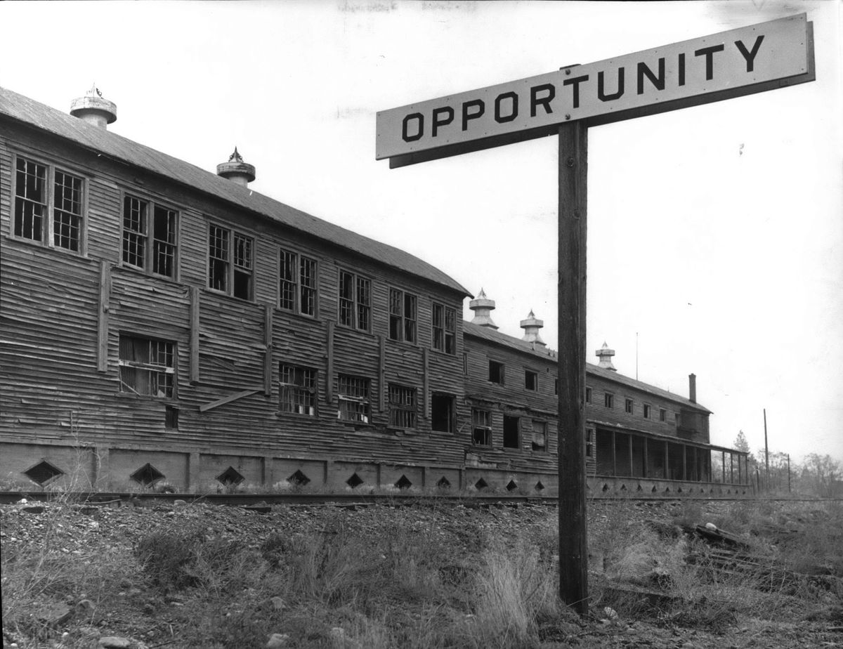 1962 - A railroad sign marks Opportunity, a township formed in 1909. But people of Opportunity were complaining about this giant apple-packing shed at 108 S. Union Road in Spokane Valley, saying it was an eyesore and an attractive nuisance for children and transients. It was one of several large fruit-packing operations dating back to the heyday of apple growing in the valley. The building sat alongside the Spokane and Inland Empire Railroad tracks that went from Spokane to Coeur d’Alene. The building was later torn down.