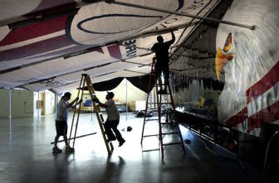 
Joseph P. Miller, left, and Bobby Clifford, center, of Spokane, help Jack Kellerman of Hacienda Customs USA, of Scottsdale, Ariz., tie down an awning that will shelter the display of motorcycles and merchandise for this weekend's Orange County Choppers tour. 
 (Photos by DAN PELLE / The Spokesman-Review)