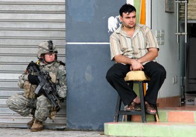 
A soldier from the 172nd Stryker Brigade Combat Team squats by a shopkeeper in central Baghdad's Karradah district Thursday. U.S. and Iraqi forces  continued searches  for a missing U.S. soldier. 
 (Associated Press / The Spokesman-Review)
