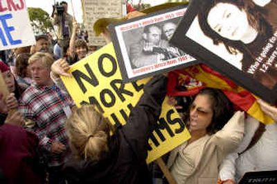 
Sunshine Lopez, back to camera, tries to keep Michael Jackson fan signs off of Sofia Hollum's sign which reads 