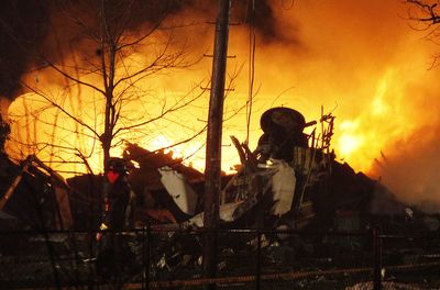A plane burns after crashing into a house in Clarence, N.Y., near Buffalo, late Thursday. Authorities said it was Continental Connection Flight 3407.  (Associated Press / The Spokesman-Review)
