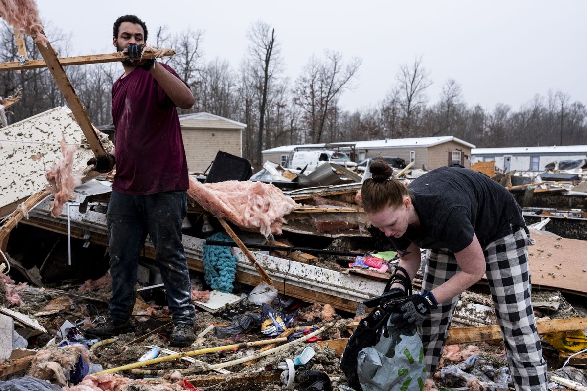 Anthony Hudson, left, helps his sister, Kelsey Webb, search through her destroyed home inside of Harmony Hills trailer park on Saturday in Poplar Bluff, Mo. (Brad Vest)