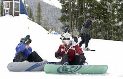
Stefani Enfield, 18, of Post Falls, helps her 12-year-old brother, Austin Enfield, left, with his snowboard for much-appreciated late-season skiing at Silver Mountain on Saturday. 
 (Tom Davenport/ / The Spokesman-Review)