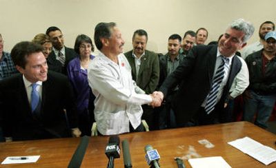 
United Farm Workers of America President Arturo Rodriguez, left, shakes hands with Global Horizons President Mordechai Orian at a news conference Tuesday after the two signed documents improving wages and benefits for workers brought into the U.S.
 (Associated Press / The Spokesman-Review)