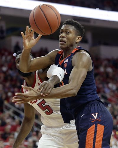 Virginia’s De’Andre Hunter and North Carolina State’s Eric Lockett (5) reach for the ball during the second half of an NCAA college basketball game in Raleigh, N.C., Tuesday, Jan. 29, 2019. Virginia won 66-65 in overtime. (Gerry Broome / Associated Press)