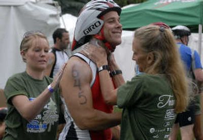 
Chris Phenicie, of Missouri City, Texas, has sunscreen applied by volunteers Miranda Snook, left, of Hayden, and Dixie Ziegler, of Post Falls. 
 (J. BART RAYNIAK / The Spokesman-Review)