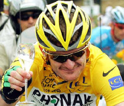 
American Floyd Landis toasts with a glass of champagne as he pedals during the final stage.
 (Associated Press / The Spokesman-Review)
