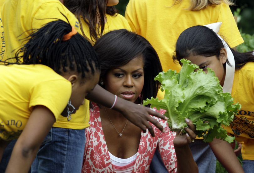 ORG XMIT: DCAB145 First lady Michelle Obama harvests vegetables with fifth graders from Bancroft Elementary School in the First Lady's Garden that they planted in the garden on the South Lawn of The White House in Washington, Tuesday, June 16, 2009.(AP Photo/Alex Brandon) (Alex Brandon / The Spokesman-Review)