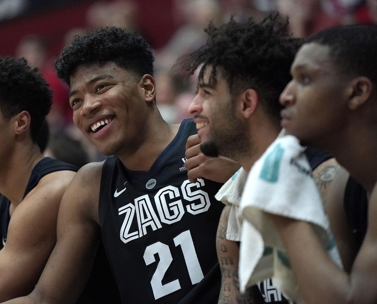Gonzaga forward Rui Hachimura (21) and teammate Josh Perkins smile as they sit on the bench at the end of the team