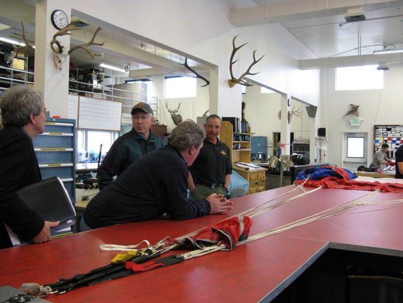 From left, BLM Director Robert Abbey, Interior Secretary Ken Salazar, and Idaho Congressman Mike Simpson learn about how smokejumpers' parachutes are packed from Hector Madrid, base manager for BLM smokejumpers at the National Interagency Fire Center in Boise. The officials toured the center Thursday and got a briefing on the upcoming wildfire season. (Betsy Russell)