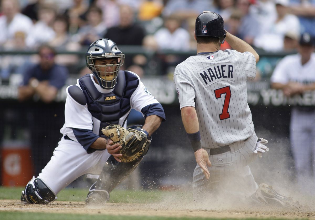 Mariners catcher Jamie Burke can’t tag out Minnesota’s Joe Mauer at the plate in the fifth inning. The run tied the game at 2. (Associated Press / The Spokesman-Review)