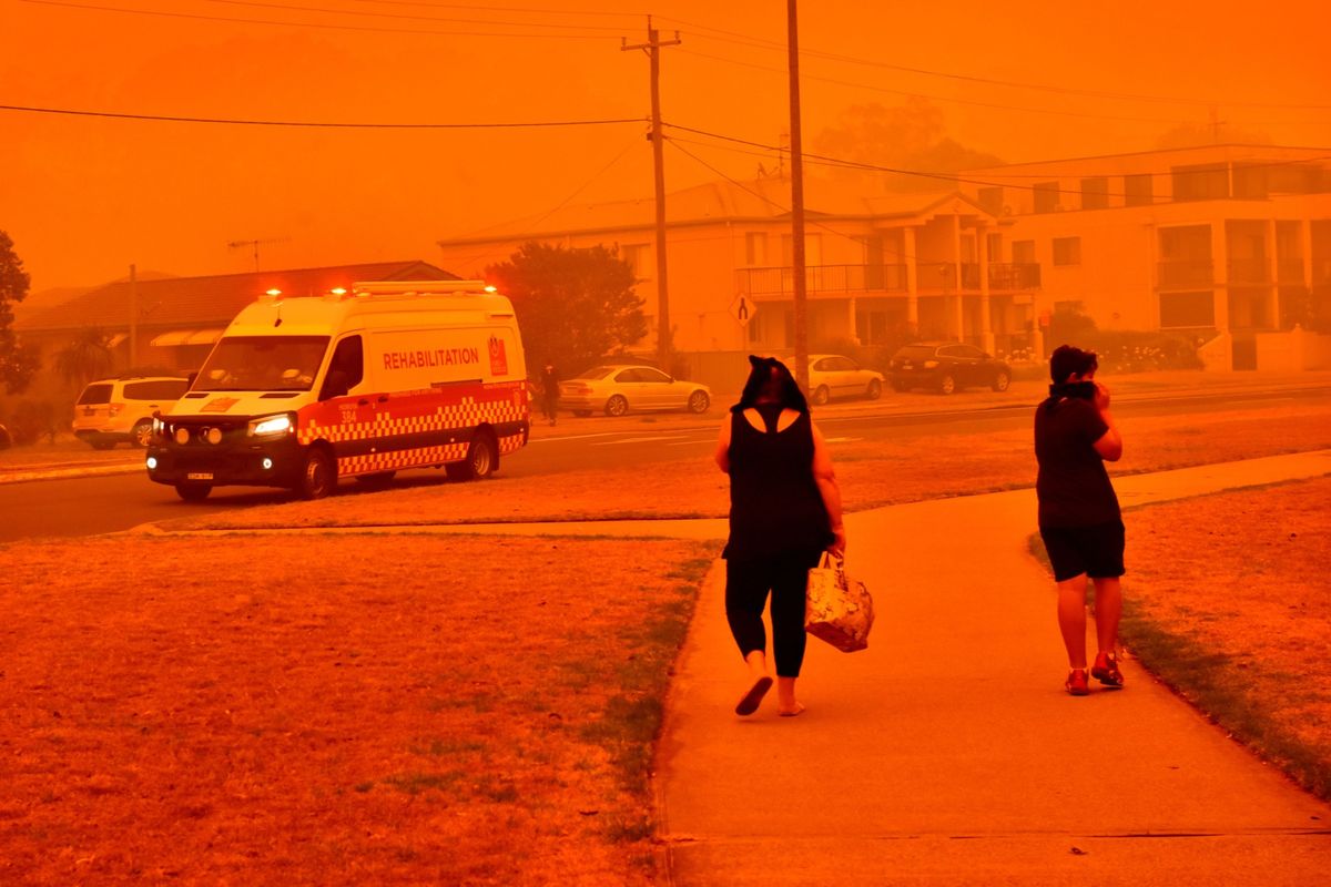 Pedestrians along a road shrouded in smoke in New South Wales, Australia, in 2019.    (Mark Graham/Bloomberg)
