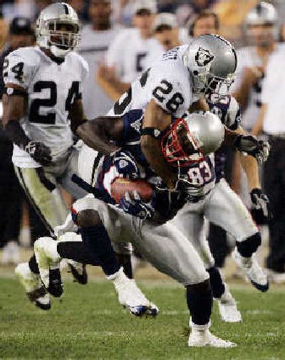 
Raiders' Standford Routt collars Deion Branch.
 (Associated Press / The Spokesman-Review)