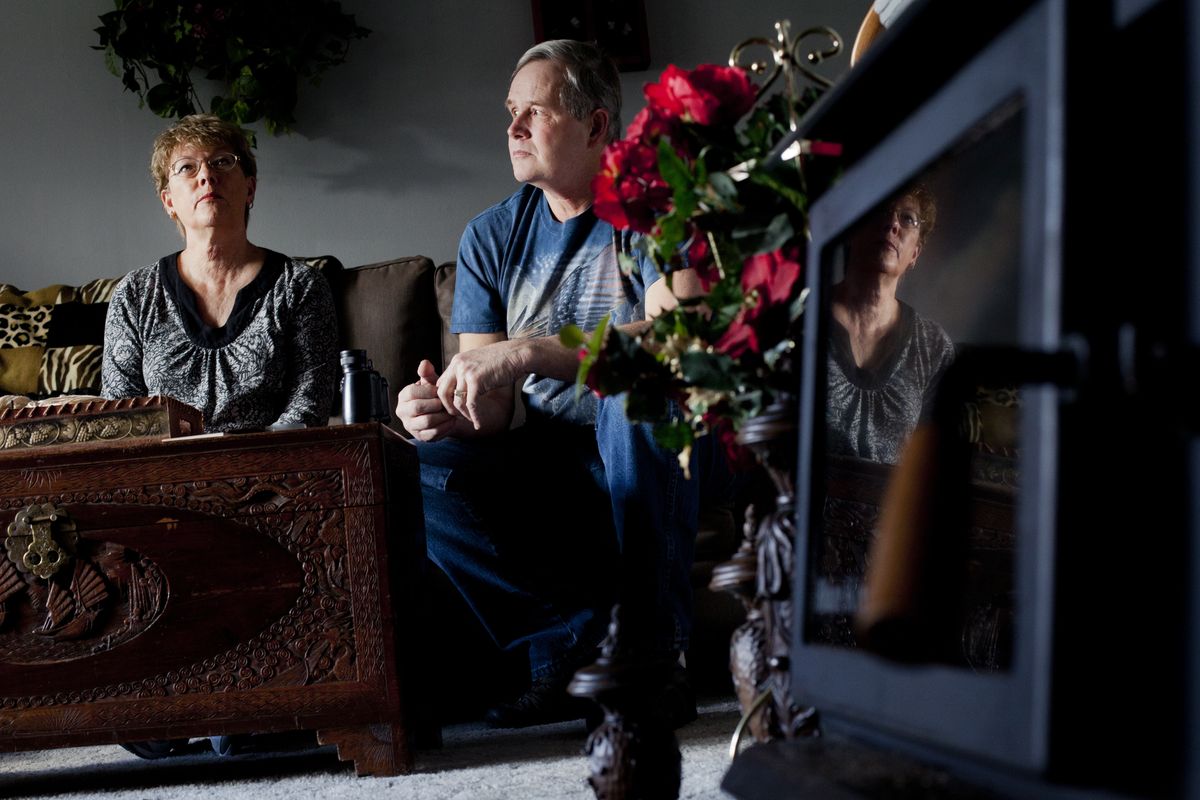 Gloria Martin and her husband, Herb Usher, sit beside their wood stove on Feb. 6 in their Spokane Valley home. The couple received a letter from the Spokane Regional Clean Air Agency about smoke levels coming from their wood stove, a problem they quickly fixed.