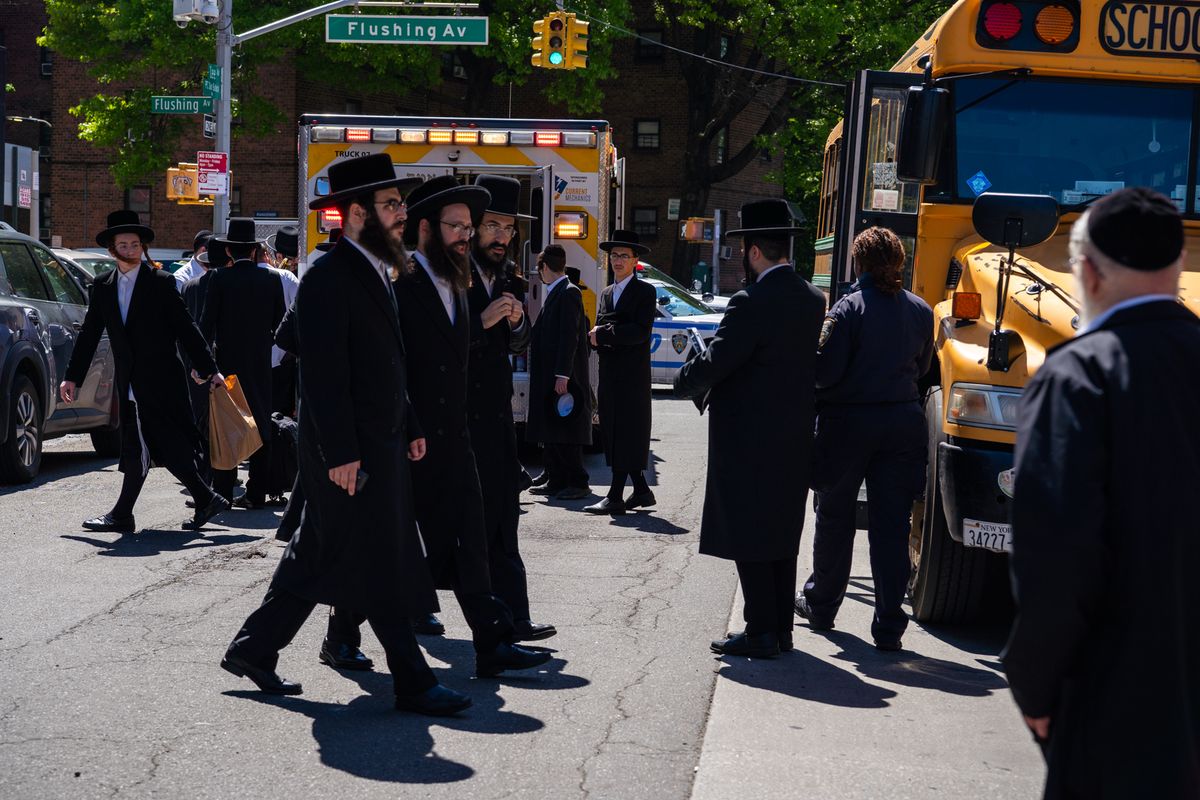 Community members gather near the site in Brooklyn where a 9-year-old boy was struck and killed by a school bus, on Friday, May 1, 2026. (Madison Swart/The New York Times)