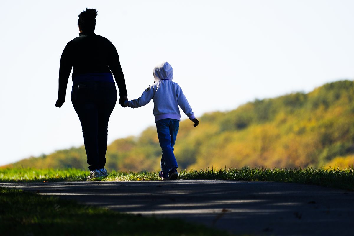 FILE - A woman and child walk on a trail at Valley Forge National Historical Park in Valley Forge, Pa., Nov. 1, 2021. Senate Democrats and Republicans each want to flash election-year signals that they’re helping families struggling with rising costs and the two-year-old pandemic. But the parties differ over how to do that. (Matt Rourke)