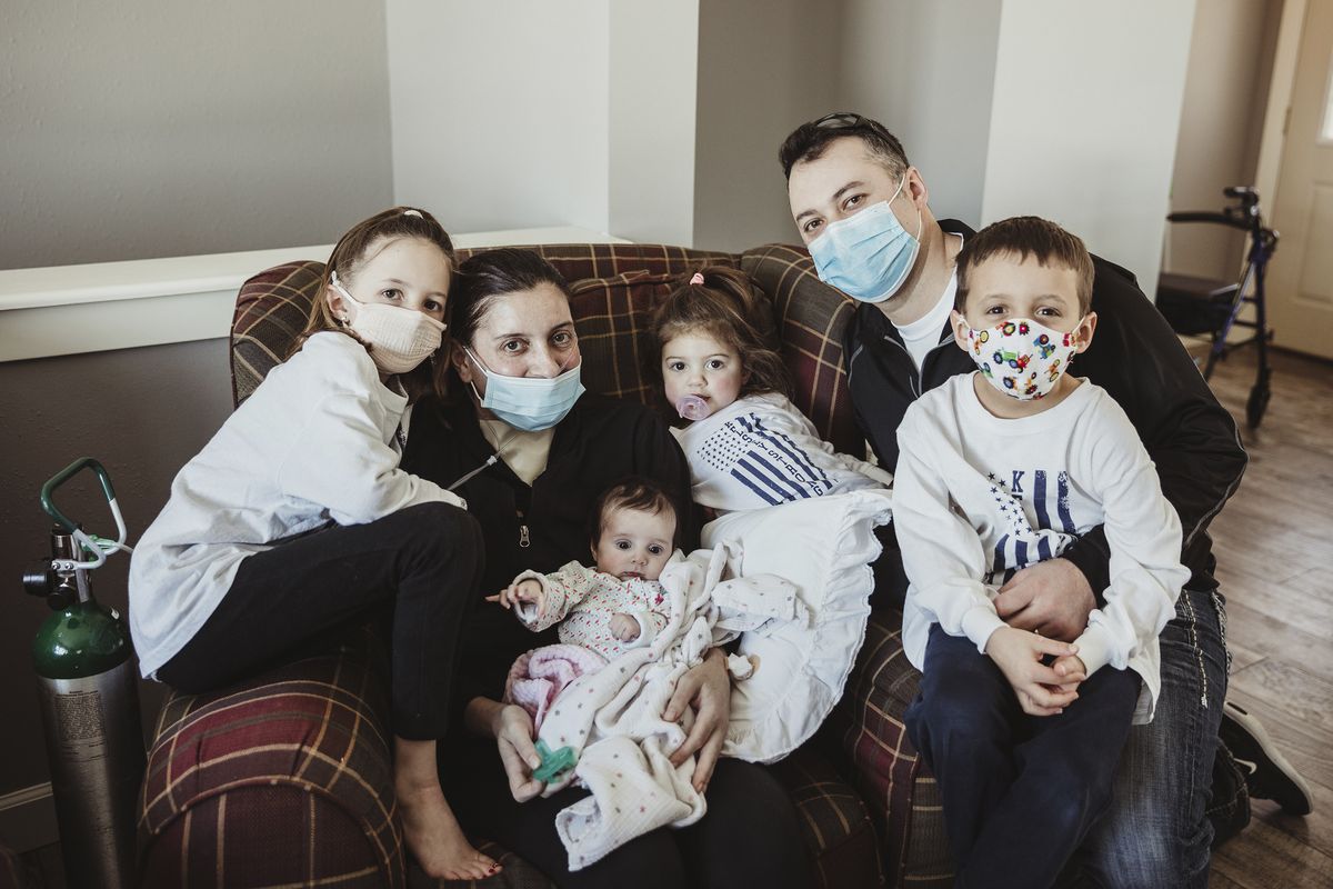 In this Jan. 27, 2021 photo provided by Taryn Marie Photography, the Townsend family poses for a photo in Poynette, Wis. the day mother Kelsey Townsend came home from the hospital, nearly three months after being admitted due to COVID-19. Townsend, second from left, gave birth to Lucy, in her arms, via C-section on Nov. 4 while in a medically induced coma. She spent 75 days on lung and life support. She finally met the daughter she delivered face to face on Jan. 27.  (Taryn Ziegler)