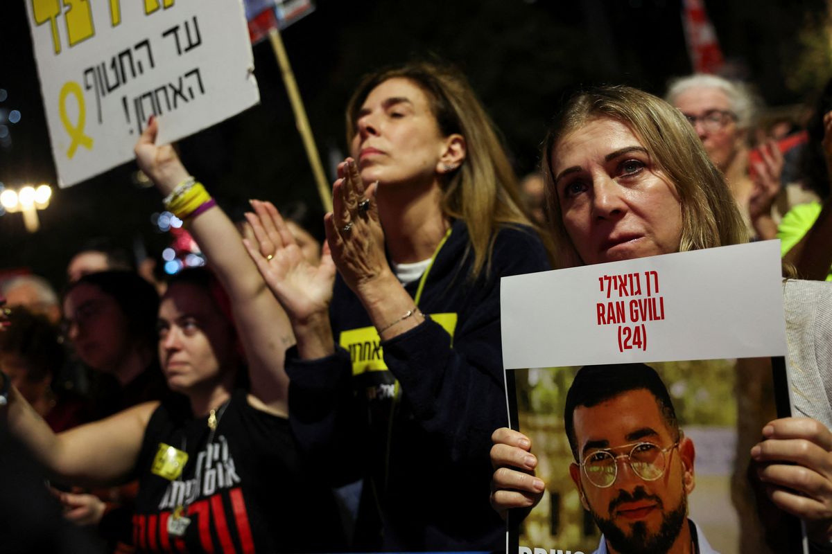 A woman holds a picture of dead hostage Ran Gvili, as Israelis attend a rally on Nov. 29 at Hostages Square in Tel Aviv, Israel, calling for the immediate return of the remains of all hostages held in Gaza.  (Reuters)