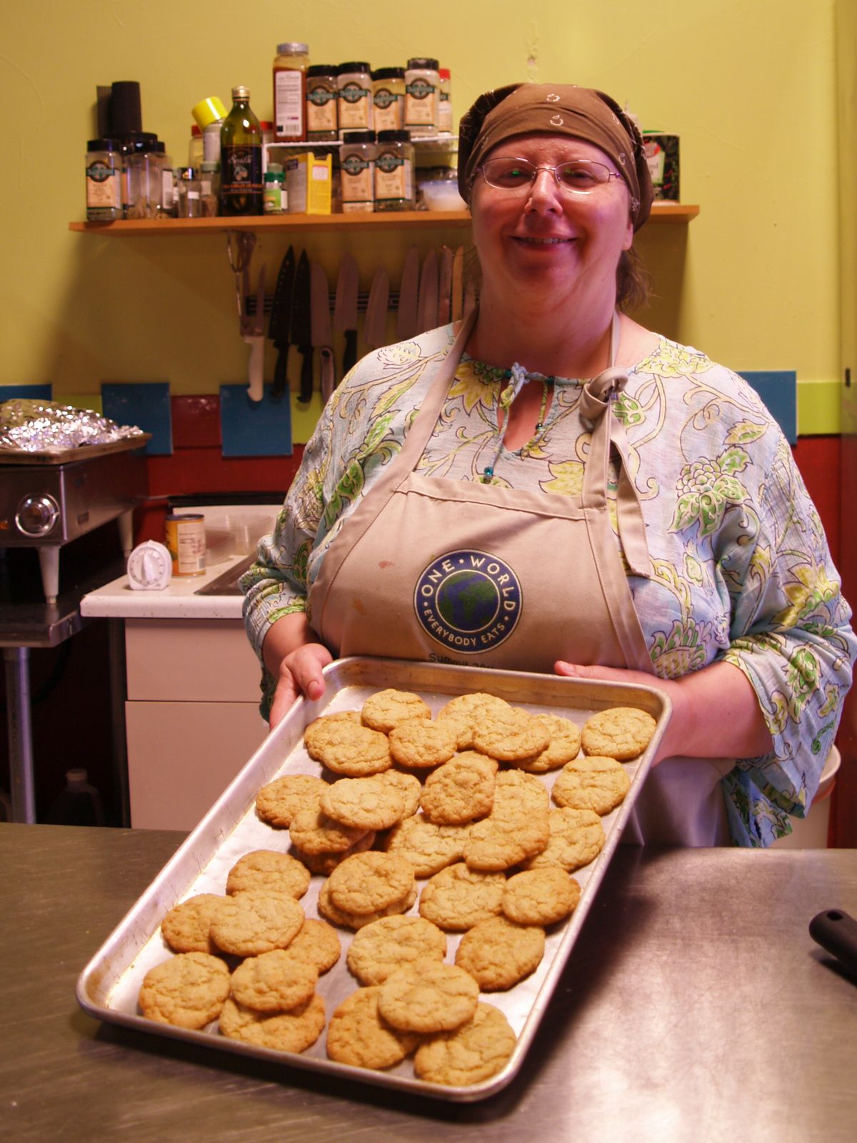 Janice Raschko shows off a tray of cookies at One World Cafe, which doesn