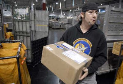 
K.C. Taylor, a priority mail clerk at the U.S. Postal Service Process and Distribution Center, sorts packages intended for troops serving in Iraq, Afghanistan and other destinations. 
 (Dan Pelle / The Spokesman-Review)