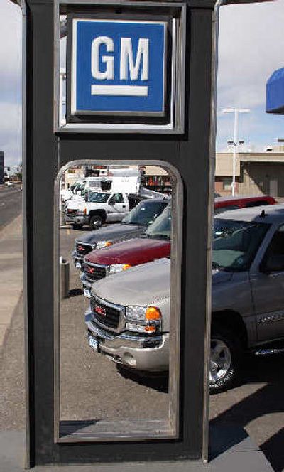 
A General Motors sign hangs over a long line of GMC pickup trucks sitting unsold on the lot of a GMC dealership in the south Denver suburb of Littleton, Colo.
 (Associated Press / The Spokesman-Review)