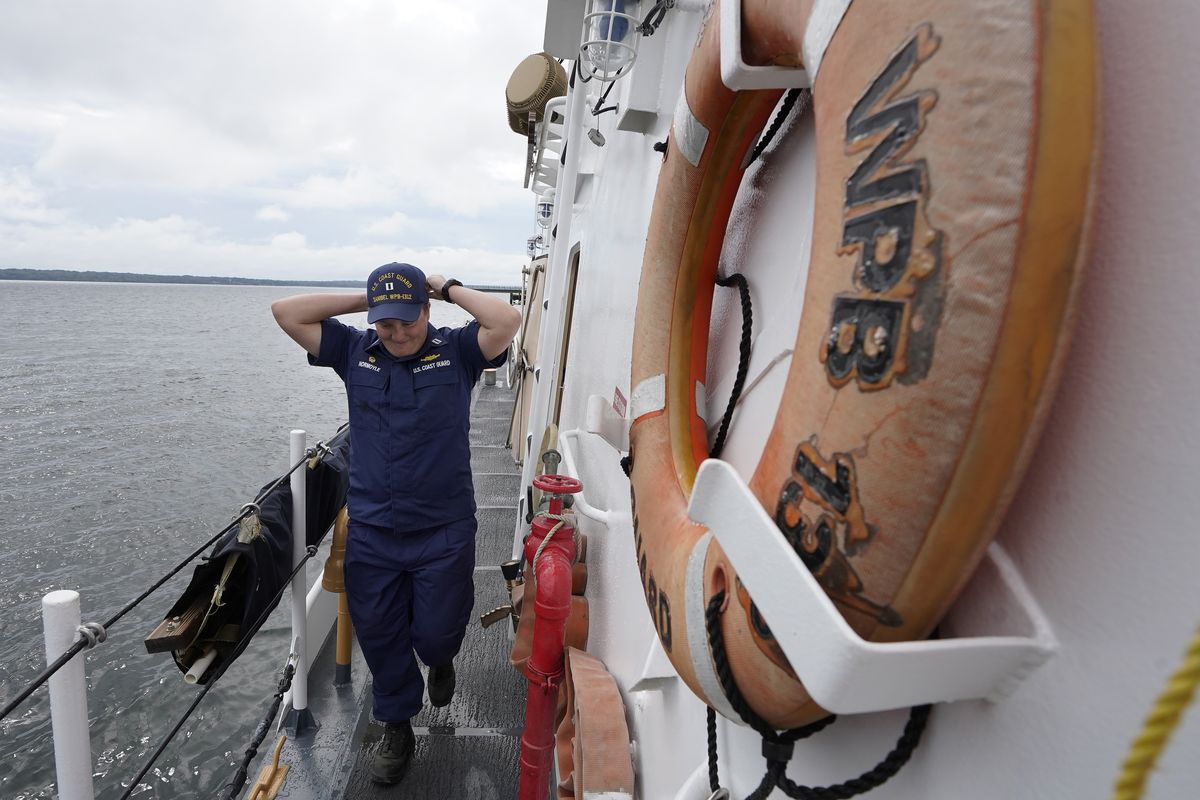 U.S. Coast Guard Lt. Kelli Normoyle, Commanding Officer of the Coast Guard Cutter Sanibel, adjusts her hat while walking on the deck of the vessel, Thursday, Sept. 16, 2021, at a shipyard in North Kingstown, R.I. Normoyle was one of two cadets who formally started the process to create the CGA Spectrum Diversity Council just a few months after the law known as "don't ask, don't tell" was repealed on Sept. 20, 2011.  (Steven Senne)