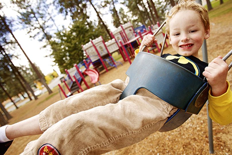 Keegan Day, 4, plays on one of the swings at White Park in Post Falls during a trip Monday to the oark with his father. (Jerome Pollos/press)