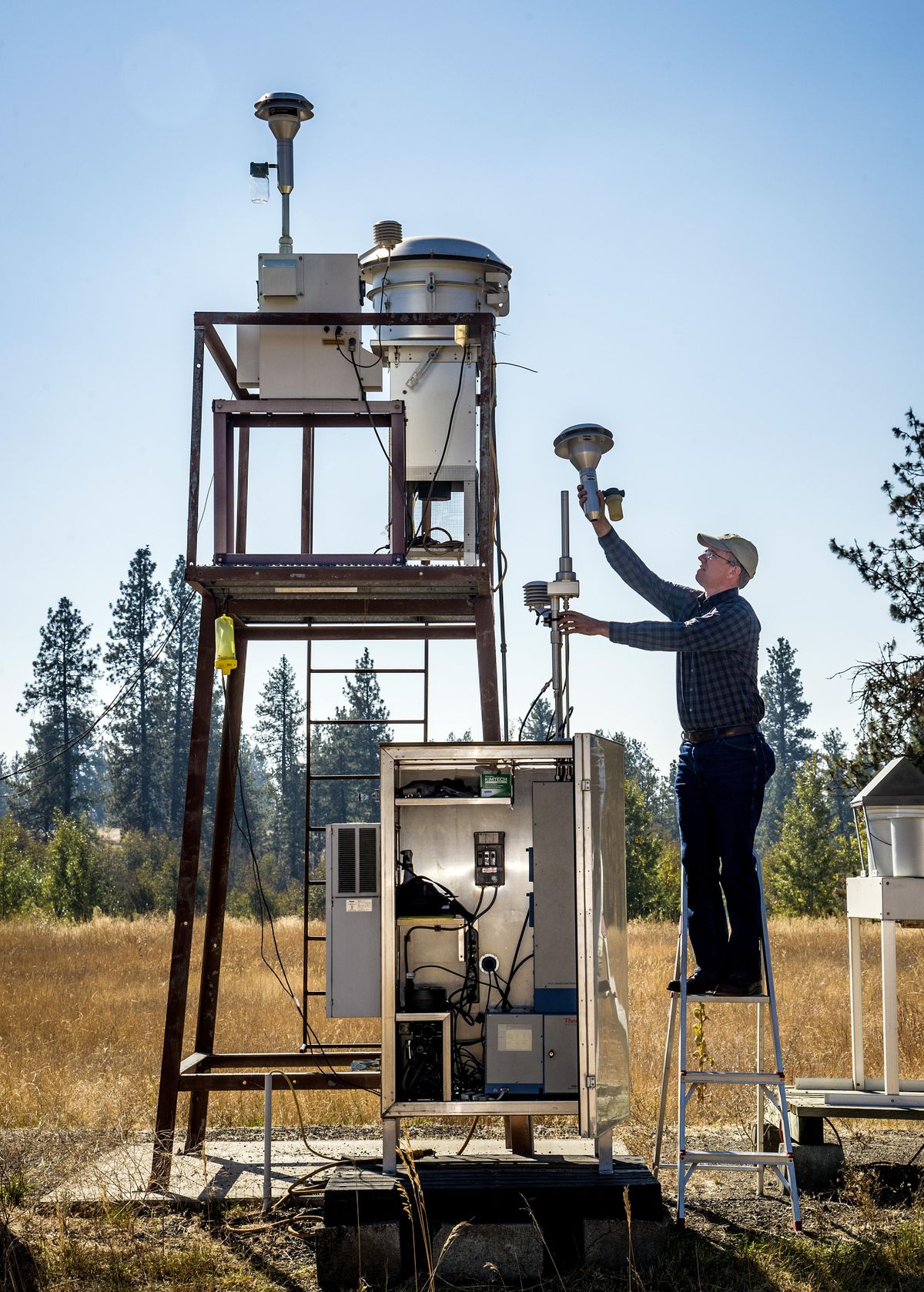Mark Rowe, an air quality technician with the Spokane Regional Clean Air Agency performs maintenance on air quality measuring equipment at Turnbull National Wildlife Refuge south of Cheney. (Colin Mulvany)