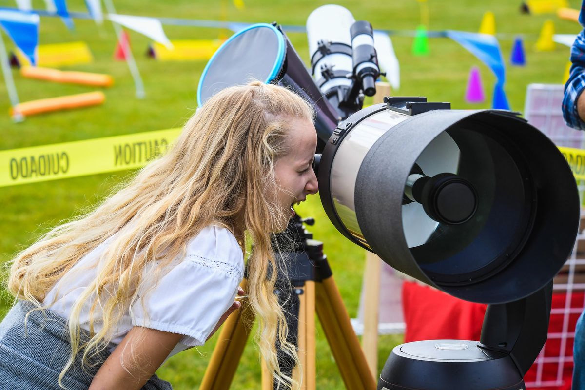 Sophia Lawson, 10, of Spokane County, gets a view of Arbor Crest Wine Cellars from Mirabeau Point Park through a Spokane Astronomical Society 8-inch telescope, Saturday, Sept. 22, 2018, during Valleyfest. (Dan Pelle / The Spokesman-Review)