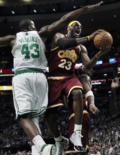 Cleveland’s LeBron James drives past Boston’s Kendrick Perkins for two of his 21 first-quarter points. He finished with 38. (Associated Press)