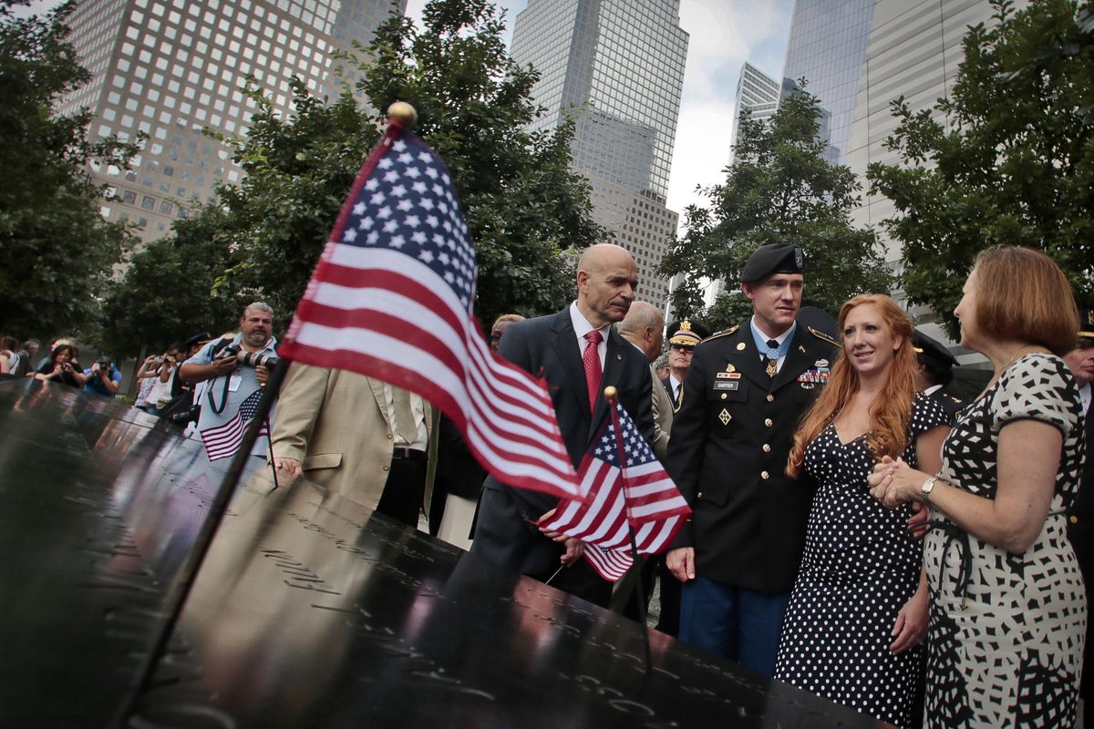 Ty Carter, third from right, and his wife, Shannon, second from right, are escorted on a tour of the 9/11 Memorial by New York officials on Aug. 29. (Associated Press)
